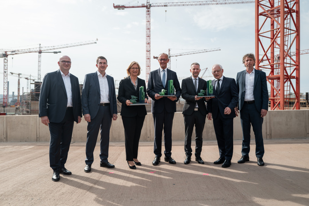 Starkes Bekenntnis zur Transformation: Bundeskanzler Friedrich Merz, Ministerpräsidentin Anke Rehlinger und Wirtschaftsminister Jürgen Barke mit der SHS – Geschäftsführung. Als Geschenk für die Gäste gab es die Transformation im Mini-Format: ein Modell der Direktreduktionsanlage und eines Elektrolichtbogenofens - Photo: SHS