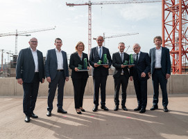 Starkes Bekenntnis zur Transformation: Bundeskanzler Friedrich Merz, Ministerpräsidentin Anke Rehlinger und Wirtschaftsminister Jürgen Barke mit der SHS – Geschäftsführung. Als Geschenk für die Gäste gab es die Transformation im Mini-Format: ein Modell der Direktreduktionsanlage und eines Elektrolichtbogenofens