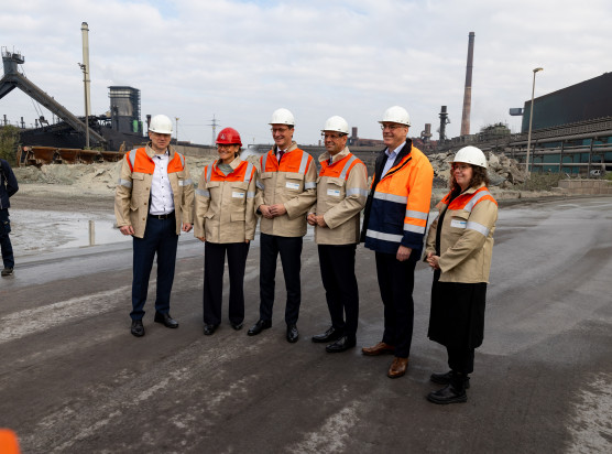 Andreas Betzler, Sprecher der Geschäftsführung der HKM, Christiane Benner, Erste Vorsitzende der IG Metall, Hendrik Wüst, Ministerpräsident Nordrhein-Westfalen, Olaf Lies, Ministerpräsident Niedersachsen, Gunnar Groebler, Vorstandsvorsitzender der Salzgitter AG, und Jule Wenzel, parlamentarische Geschäftsführerin der Grünen-Fraktion im nordrhein-westfälischen Landtag, bei der Besichtigung des Baufelds für den HKM-Elektrolichtbogenofen.